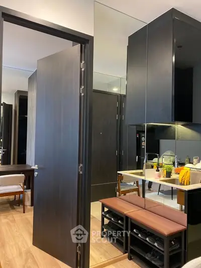 Modern kitchen with sleek cabinetry and mirrored accents in a stylish apartment.