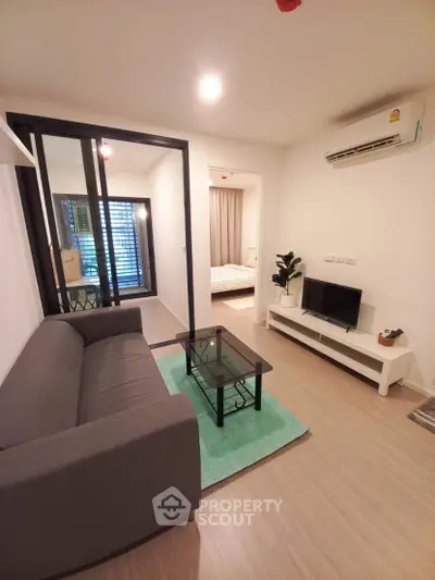 Modern living room with sleek furniture and open view to bedroom, perfect for urban living.