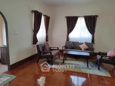 Charming living room with cozy seating and natural light, perfect for relaxation and entertaining.