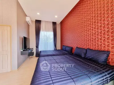 Spacious modern bedroom with textured accent wall and large windows