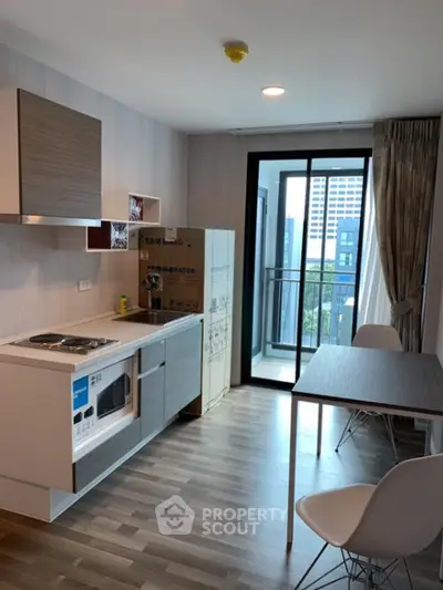 Modern kitchen with open layout and balcony view in urban apartment