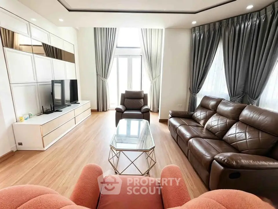 Spacious modern living room with leather sofas and large windows