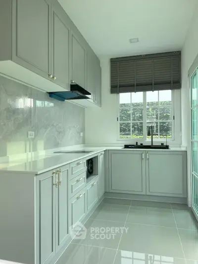 Modern kitchen with sleek cabinetry and large window for natural light