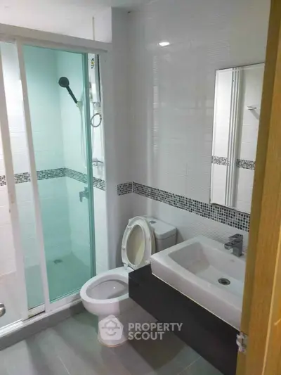 Modern bathroom with glass shower enclosure and sleek fixtures.