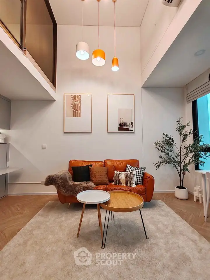 Modern living room with high ceiling, stylish lighting, and cozy leather sofa in a chic apartment.