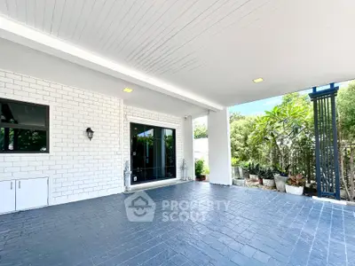 Spacious covered patio with modern design and lush greenery