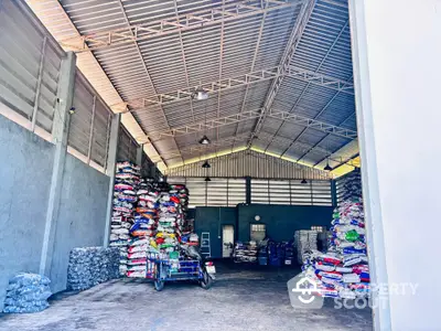 Spacious warehouse interior with high ceilings and stacked goods