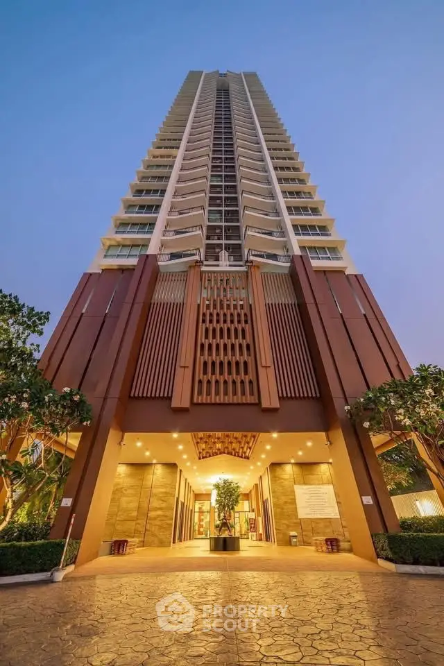 Stunning high-rise building entrance with modern architectural design and lush greenery.