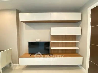 Modern living room with sleek wall-mounted TV unit and stylish shelving.