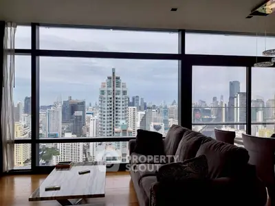 Luxurious living room with stunning city skyline view from high-rise apartment.