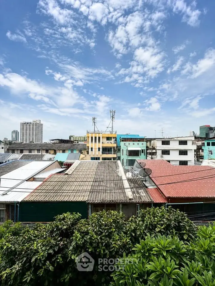 Scenic urban view showcasing colorful rooftops and lush greenery under a vibrant blue sky.