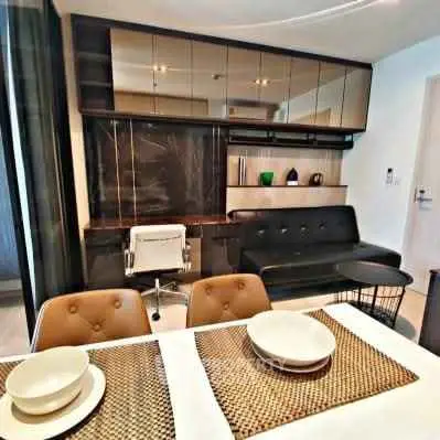 Modern living room with sleek furniture and dining area in a stylish apartment.