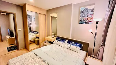 Modern bedroom with stylish decor and mirrored wardrobe in cozy apartment.