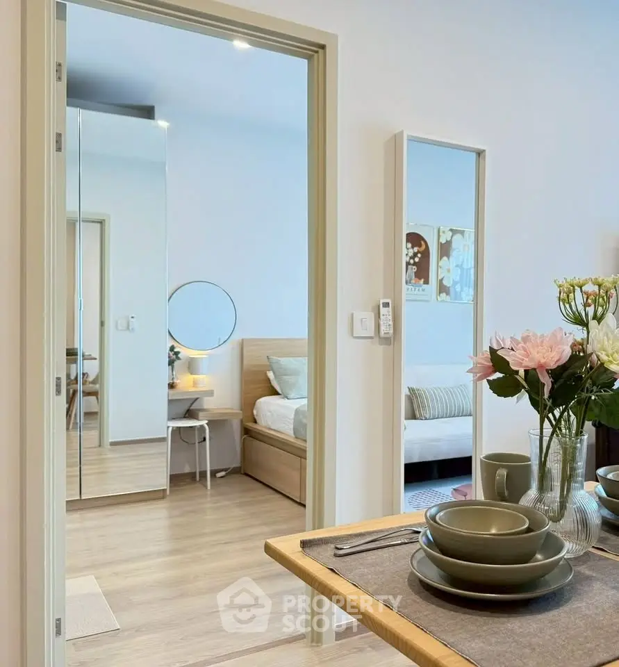 Modern open-plan living and dining area with stylish decor and cozy bedroom view.