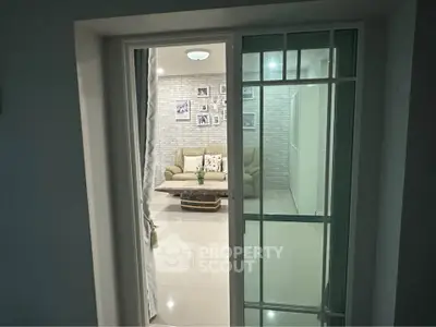 Cozy living room with modern decor and sliding glass door entry.