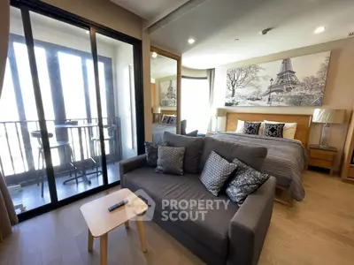 Modern studio apartment with cozy living area and stylish bedroom near balcony.