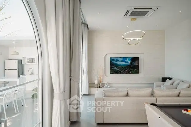 Luxurious modern living room with elegant decor and open kitchen layout.
