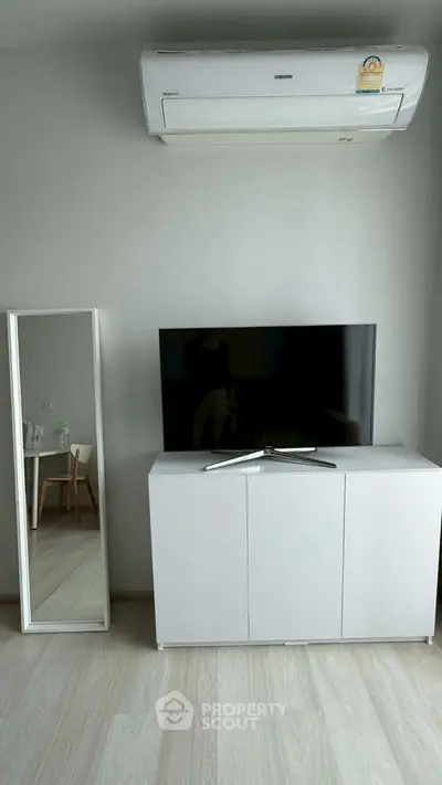 Modern living room with sleek TV stand and air conditioning unit, perfect for comfortable living.