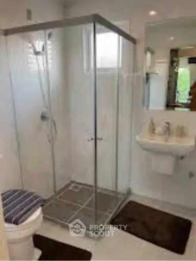 Modern bathroom with glass shower enclosure and sleek fixtures