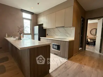 Modern kitchen with sleek cabinetry and built-in oven in a stylish open layout.