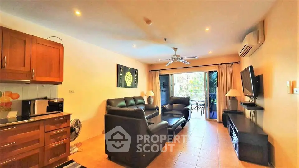 Spacious living room with modern furniture and balcony view in a cozy apartment.