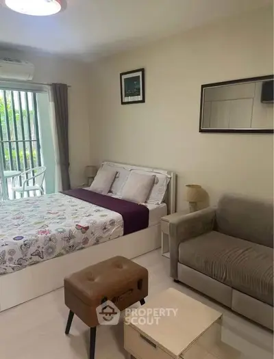 Cozy bedroom with modern decor and balcony view, perfect for urban living.