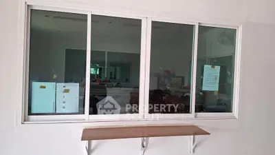 Modern window with reflective glass and wooden shelf in contemporary interior space.