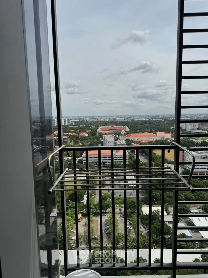 Stunning high-rise balcony view overlooking cityscape and lush greenery, perfect for urban living.