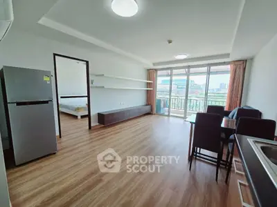 Spacious open-plan living room with dining area and balcony view in modern apartment.