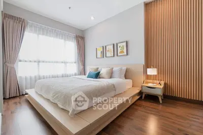 Modern bedroom with wooden flooring and stylish decor in a bright apartment.