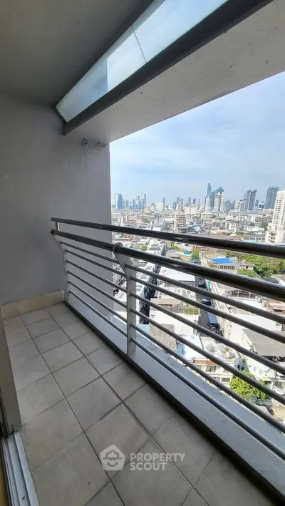 Stunning city view from a high-rise balcony with modern railing.
