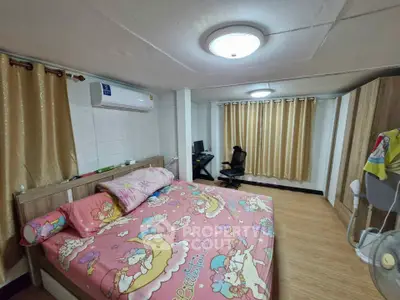 Cozy bedroom with colorful bedding and modern furnishings in a well-lit space.