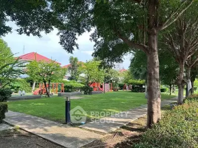 Charming residential garden with lush greenery and playground, perfect for family living.