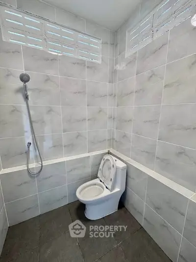 Modern bathroom with sleek tile design and minimalist shower setup.