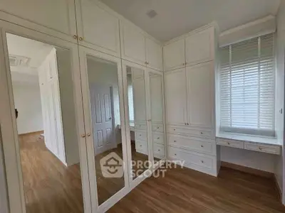 Spacious bedroom with elegant built-in wardrobes and natural light