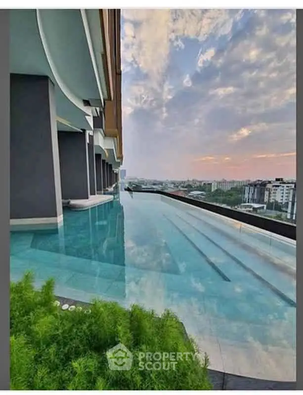 Stunning rooftop infinity pool with panoramic city views at luxury apartment complex.