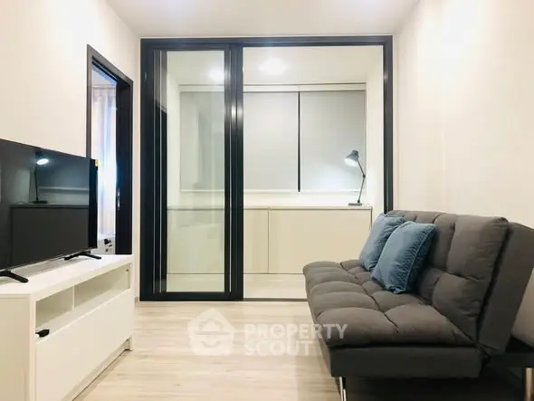 Modern living room with sleek furniture and glass partition in a stylish apartment.