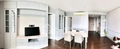 Spacious modern living room with dining area and sleek kitchen in open layout apartment.