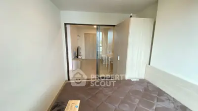 Modern bedroom with sliding glass doors and sleek furniture in a contemporary apartment.
