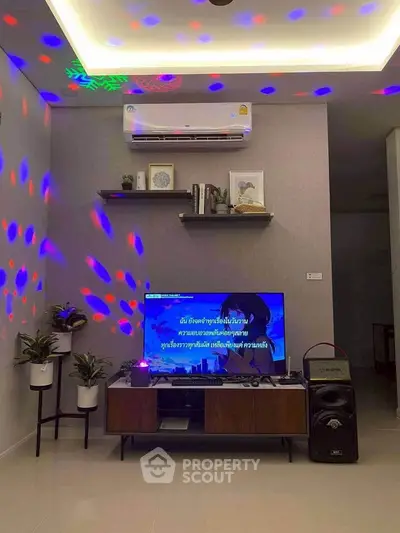 Modern living room with ambient lighting, sleek TV setup, and stylish decor for a cozy entertainment experience.