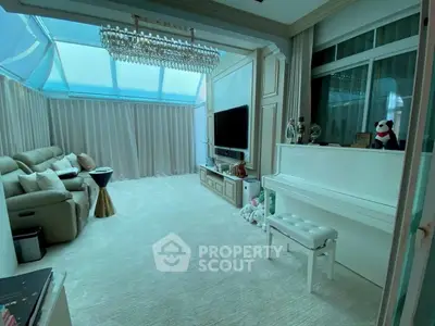 Luxurious living room with piano and elegant chandelier in sunlit space