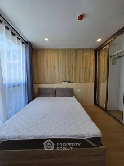 Modern bedroom with wooden accents and large window in stylish apartment