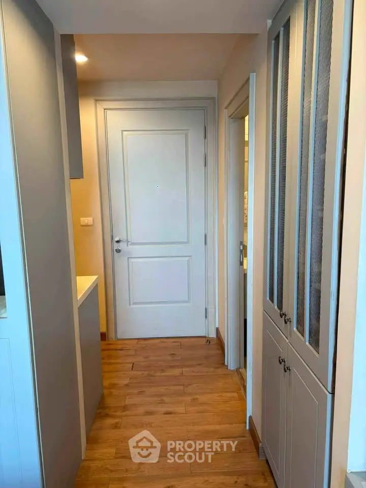 Charming hallway with wooden flooring and elegant cabinetry in modern apartment.