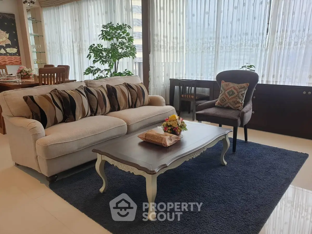 Elegant living room with plush sofa, stylish coffee table, and large windows for natural light.