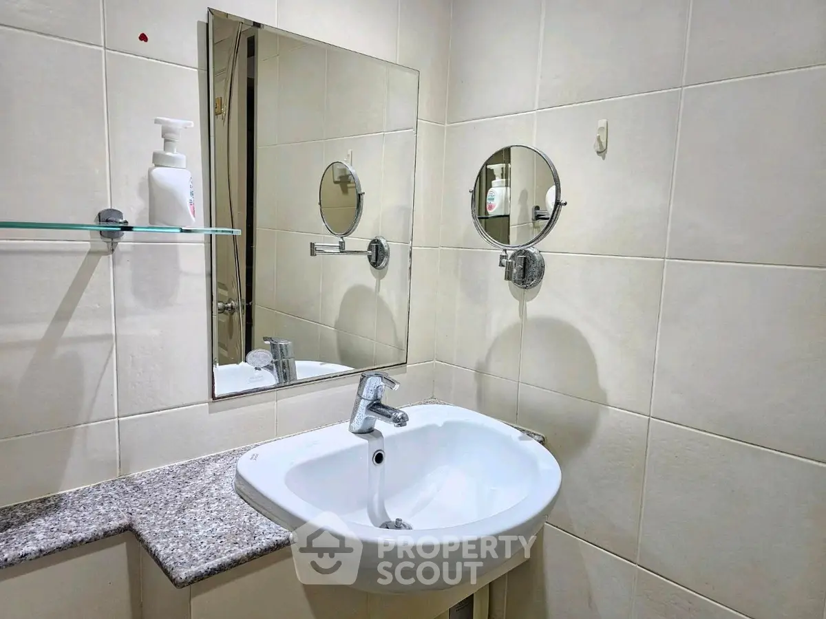 Modern bathroom with sleek sink and mirror in a stylish real estate property.