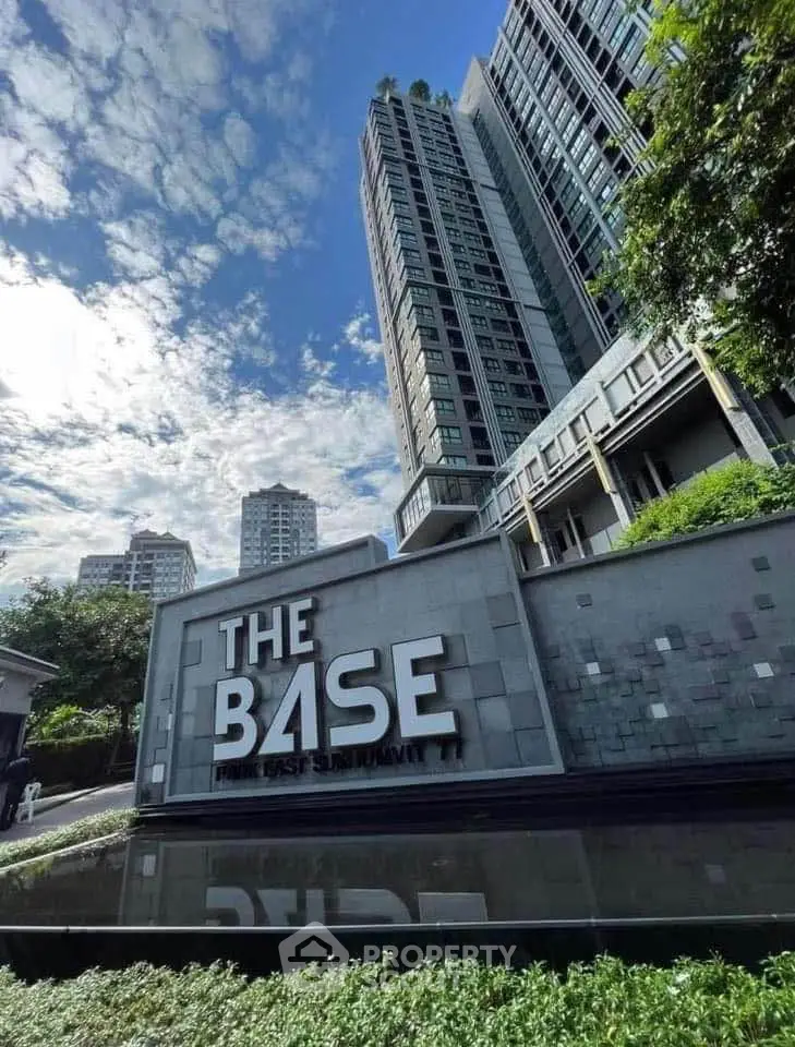 Modern high-rise condominium with lush greenery and clear sky view.