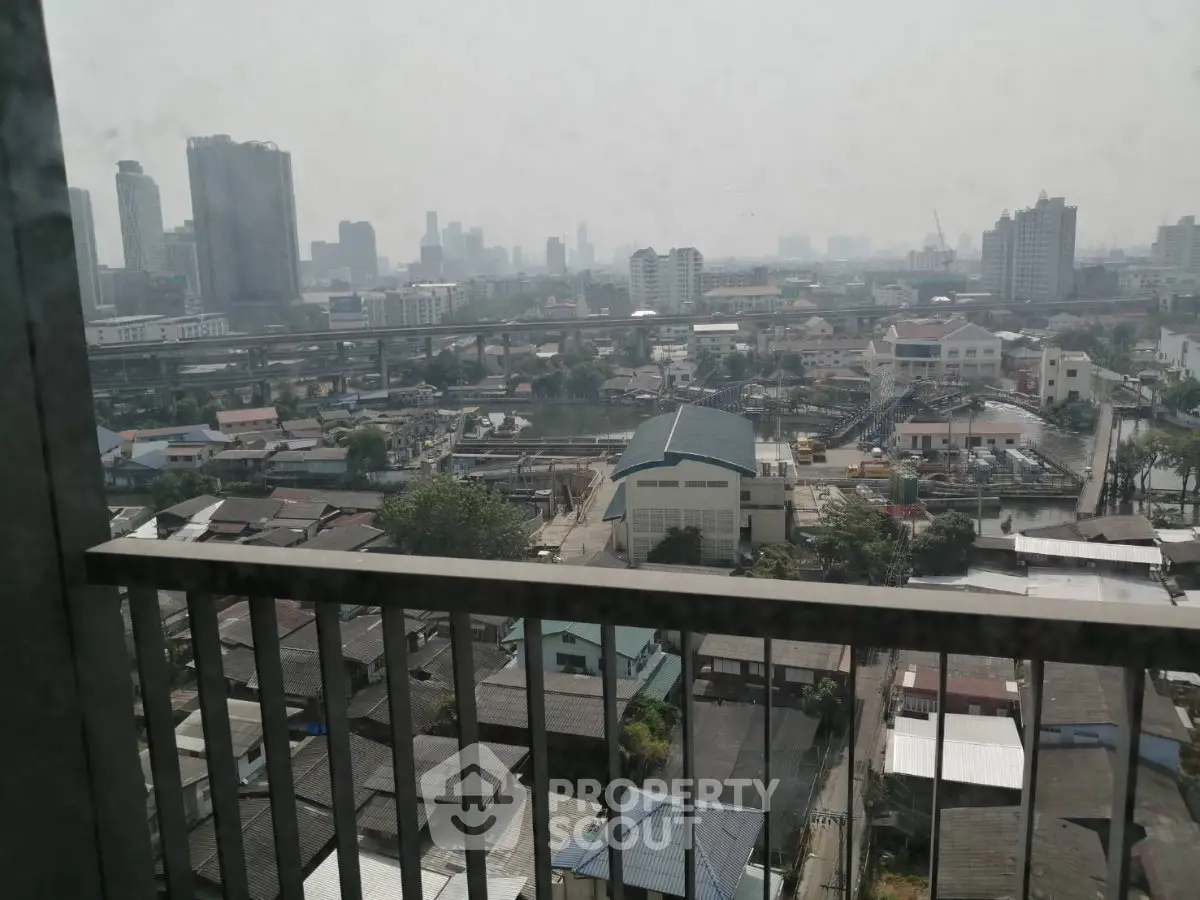 Stunning cityscape view from a high-rise balcony overlooking urban skyline and river.