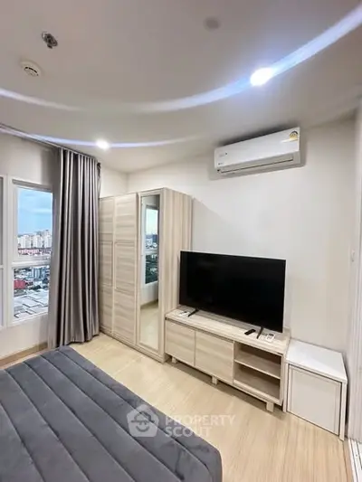 Modern bedroom with city view, featuring sleek furniture and air conditioning.