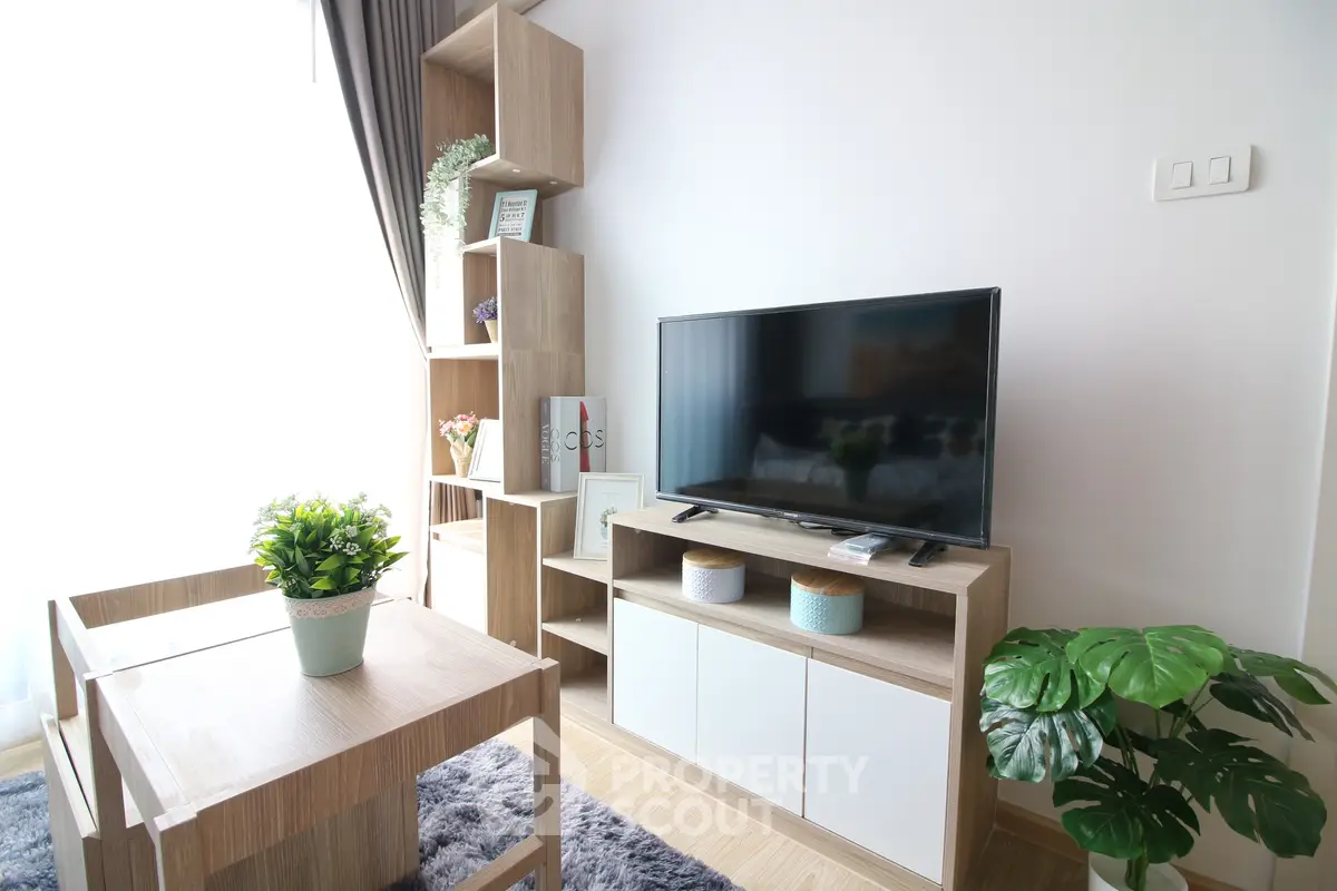 Modern living room with stylish wooden furniture and large TV, perfect for cozy relaxation.