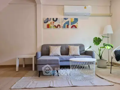 Modern living room with stylish decor, featuring a comfortable sofa, abstract art, and a chic coffee table.